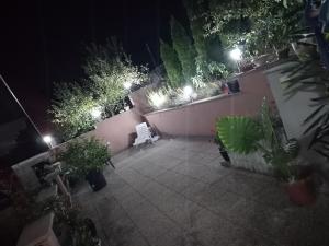 图兹拉Apartment AMRA的夜晚的庭院,有白色的长凳和植物