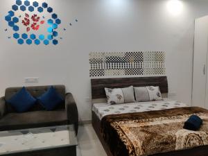 诺伊达The Forest Stays-Luxury Studio Apartment In Noida的一间卧室配有一张床、一张沙发和一个时钟