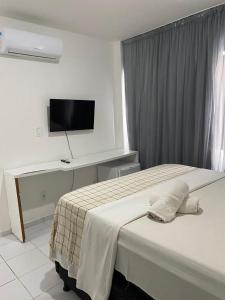 马塞约马塞约海滨宾馆的卧室配有一张床,墙上配有电视。