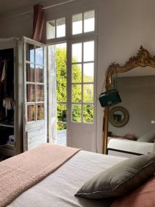 埃特勒塔La Villa Lumaga的一间卧室配有一张床、镜子和窗户