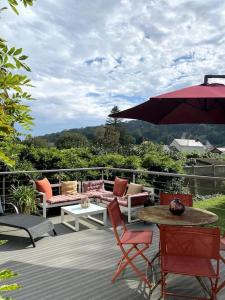 埃特勒塔La Villa Lumaga的庭院配有桌椅和遮阳伞。