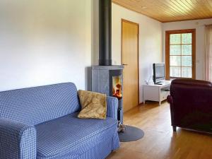 本茨福什Holiday home BENGTSFORS VI的客厅设有蓝色的沙发和壁炉