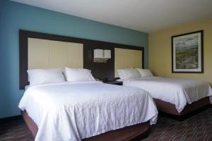 博伊西博伊西城中心智选假日酒店的配有白色床单的酒店客房内的两张床