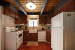 莱文沃思Leavenworth Mountain View Cabin w/ Space to Hike的厨房配有棕色橱柜和白色冰箱