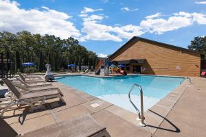 布兰森Rock and Timber Lodge的一个带两把椅子的游泳池和一个游乐场