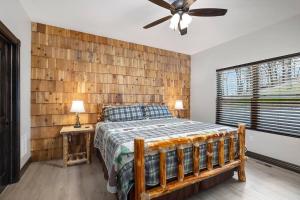 布兰森Rock and Timber Lodge的一间卧室设有一张床和木墙