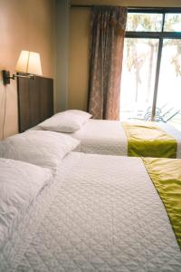 曼塔HOTEL MANTA BEACH MADRIGAL的窗户房间里一排三张床
