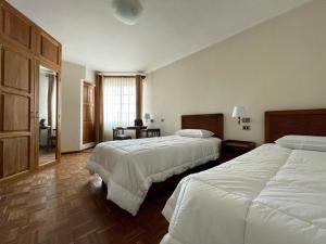 苏克雷HOSPEDAJE SARABIA的酒店客房设有两张床和窗户。