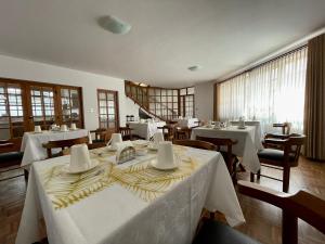 苏克雷HOSPEDAJE SARABIA的一间设有白色桌椅的用餐室