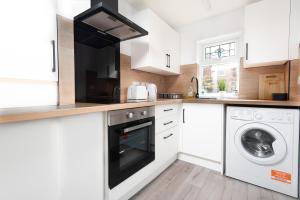 雷德卡Sandringham House的白色的厨房配有洗衣机和烘干机