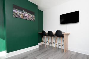 雷德卡Sandringham House的一间设有绿色墙壁和一张桌子及凳子的房间