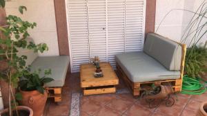 塞维利亚Familia Anfitriona acoge terraza的庭院设有两把椅子和一张茶几