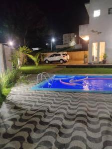 帕里普埃拉Casa de Praia em Condomínio Fechado em Alagoas!的夜间在院子里的游泳池