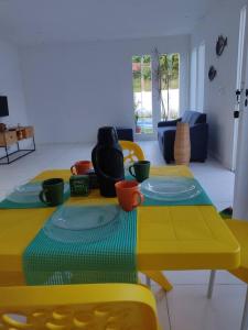 帕里普埃拉Casa de Praia em Condomínio Fechado em Alagoas!的客厅里一张带盘子的黄色桌子