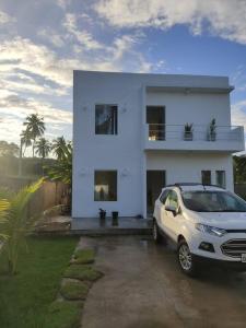 帕里普埃拉Casa de Praia em Condomínio Fechado em Alagoas!的停在白色房子前面的汽车