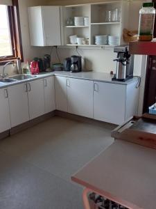 布伦迪欧斯Áfangi的一间厨房,内设白色橱柜和水槽