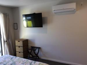 陶波相思湖景观汽车旅馆的卧室配有壁挂式平面电视。