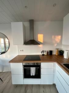 雷克雅未克Charming 1-bedroom condo with stunning view的厨房配有白色橱柜和炉灶烤箱。