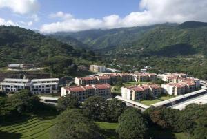 圣安娜CR MARIPOSA RENTALS Comfortable penthouse, AC, pool, gym, tennis的背景中群山校园的空中景观