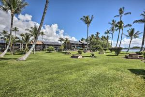 考纳卡凯Kaunakakai Home at Molokai Shores with Pool!的一座公园,在一座建筑前有长椅和棕榈树