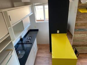 约恩维利Studio Minimalista Região Central Residencial Padre Kolb 201C的厨房设有黄色台面和黄色抽屉
