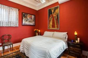 巴亚尔塔港加蓝里奥住宿加早餐旅馆的红色的卧室配有一张床,墙上挂着一幅画