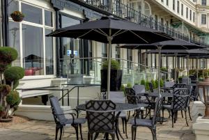 多佛尔Best Western Premier Dover Marina Hotel & Spa的一个带桌椅和遮阳伞的户外庭院。