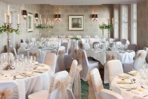 多佛尔Best Western Premier Dover Marina Hotel & Spa的宴会厅配有白色的桌椅