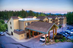 白鱼镇The Pine Lodge on Whitefish River, Ascend Hotel Collection的停车场内停车的度假村的空中景观