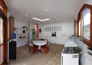 阿约拉港加拉帕戈斯白色旅舍的一间带桌子的厨房和一间带炉灶的厨房