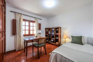 Caleta de CaballoSweet Marea的一间卧室配有一张床、一张书桌和一个窗户。