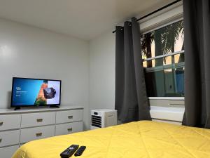 迈阿密SERENE FULL BED NEAR DOLPHIN MALL/FIU的一间卧室设有一张床、一台电视和一个窗口。