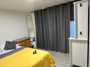 迈阿密SERENE FULL BED NEAR DOLPHIN MALL/FIU的一间卧室配有黄色的床和灰色窗帘