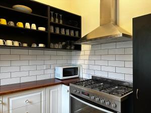 阿德莱德Glenelg House的厨房配有炉灶和微波炉。