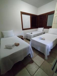 塞蒂拉瓜斯Recanto Pau Brasil的一间设有两张床铺和毛巾的房间