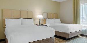 圣安东尼奥圣安东尼奥机场烛木套房酒店的酒店客房设有两张床和窗户。