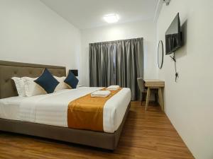 吉隆坡Le Quadri Hotel Kuala Lumpur的一间卧室配有一张床、一张书桌和一台电视