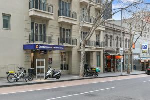 墨尔本隆斯戴尔探索旅馆的一条城市街道上的建筑,摩托车停在人行道上