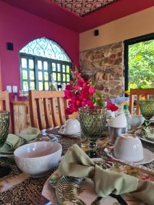 Serra de São BentoPousada Lajedo的桌上放有盘子,碗和花