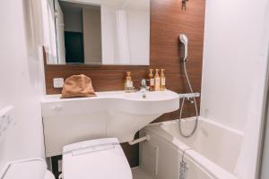 大阪R Hotel Honmachi的一间带水槽、卫生间和镜子的浴室