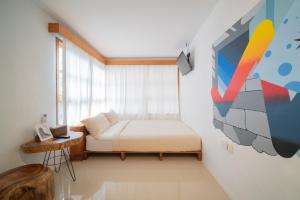 SeribuDanka Vacation Home的卧室配有一张床,墙上挂有绘画作品