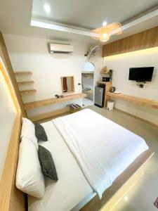 库德岛达拉民宿的卧室配有一张白色大床和电视。