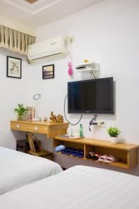 杭州西湖雷峰塔河坊街地铁口民宿的一间卧室设有两张床,墙上配有电视。