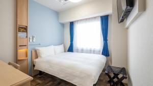 天理市Toyoko Inn Tenri Ekimae的一间小卧室,配有白色的床和窗户