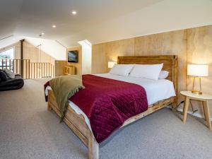 奥阿库尼Viewtopia - Ohakune Holiday Home的一间卧室配有一张带红色毯子的大床
