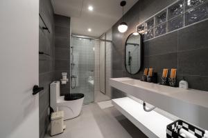 台南双层公寓 Duplex Apt.的一间带水槽、卫生间和镜子的浴室