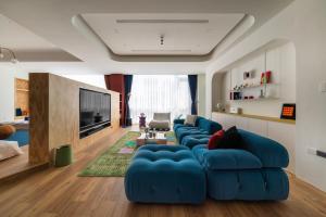 台南双层公寓 Duplex Apt.的客厅配有蓝色的沙发和电视