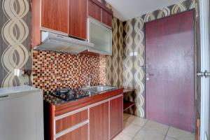 万隆OYO Life 92910 Apartemen Tamansari Panoramic By Tira的一个带木制橱柜和水槽的小厨房