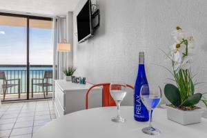 默特尔比奇Romantic Oceanfront Studio Escape w Perfect View 1212的一张桌子,上面放着两杯酒和一瓶葡萄酒