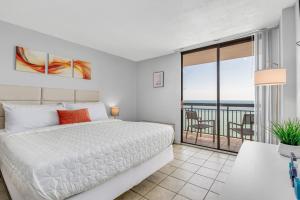 默特尔比奇Romantic Oceanfront Studio Escape w Perfect View 1212的一间白色卧室,配有床和阳台
